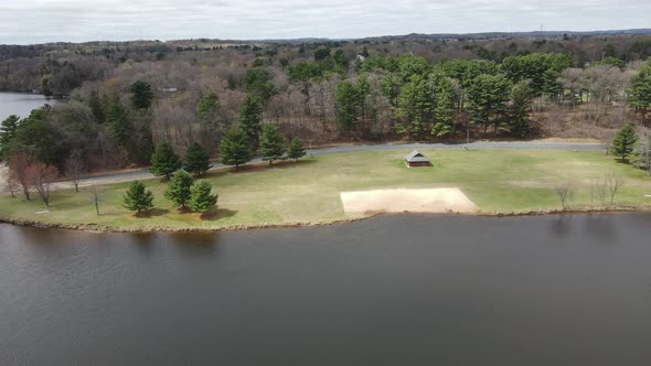Aerial of midwest park along lake in midwest Wisconsin on a cloudy day in autumn. alt