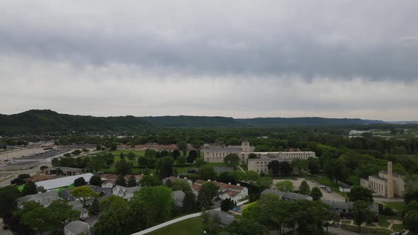 Drone view over diverse midwest neighborhood in valley with view of Mississippi River.