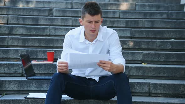 Businessman Examines Financial Statements.