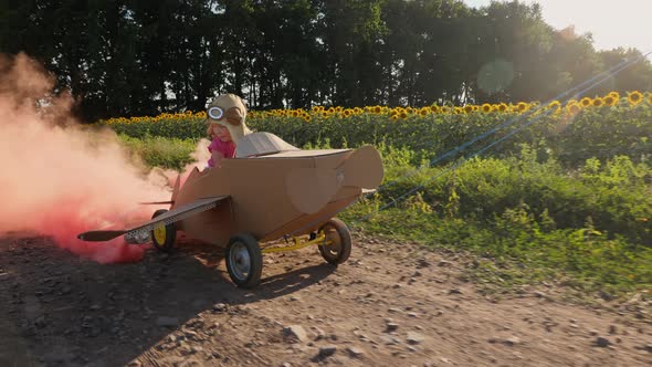 Smiling Little Girl Driving a Cardboard Plane with Smoke Bombs