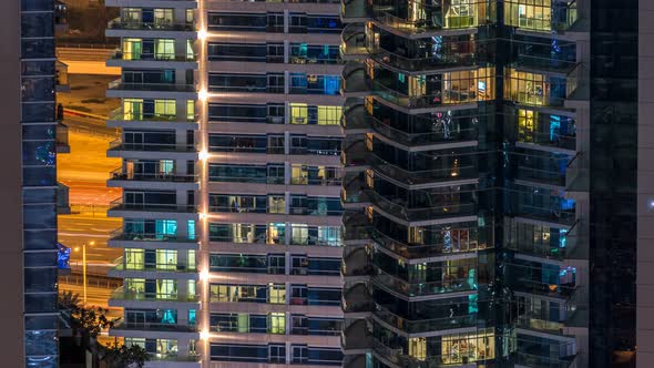 Glowing Windows in Multistory Modern Glass and Metal Residential Building Light Up at Night