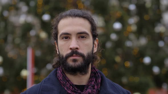 Handsome young man in the city at christmas looking at camera