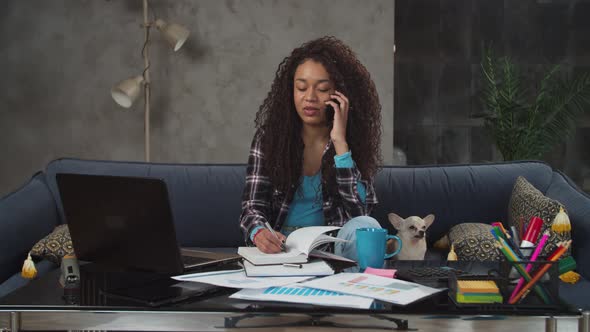 Multitasking Mixed Race Female Working in Home Office