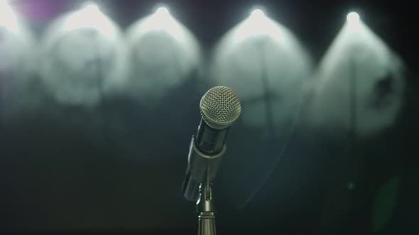 The Silhouette of the Microphone in the Dark on Stage