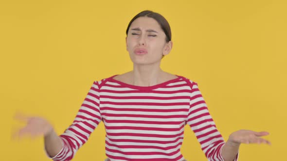 Disappointed Spanish Woman Reacting to Loss on Yellow Background