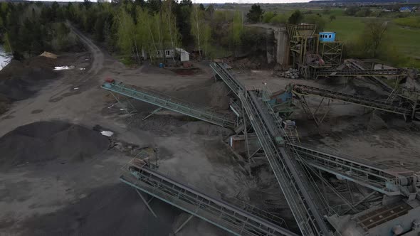 Aerial view basalt quarry of open pit mine machines with sifters and conveyor belts