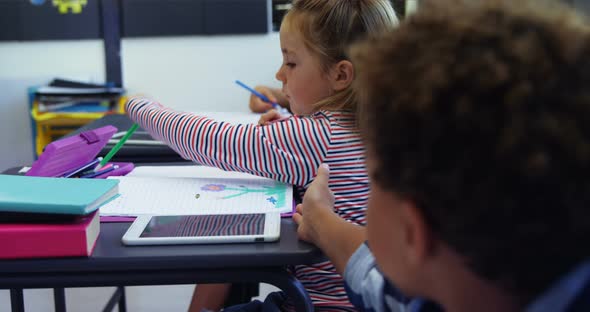 Schoolboy borrowing color pencil from his classmate