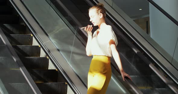 Young businesswoman on an escalator in a modern building