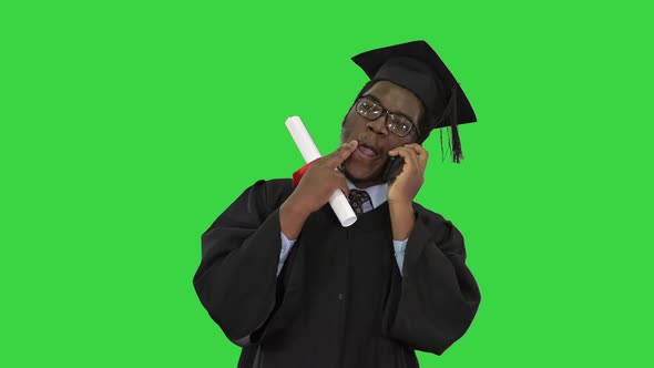 Smiling African American Male Student in Graduation Robe Talking on the Phone Sharing Happy News on