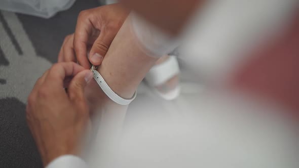 Loving Man Buckles Sandal of Young Bride Shoe in Apartment