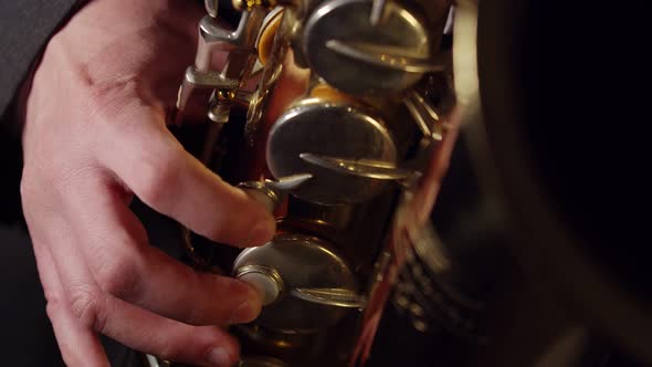 Hands of Musician Press the Valves of Saxophone Closeup