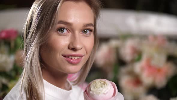 Closeup Portrait of Charming Smiling Blonde Girl with Flower Looking at Camera