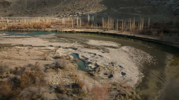 Drone Flying Over Turquoise Winding River Rising To Reveal Sweeping Valley Landscape Of Ghizer Valle