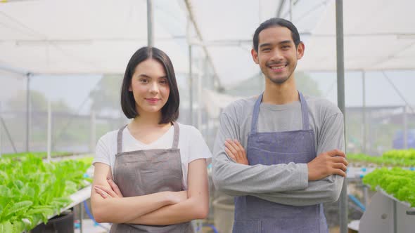 Asian couple farmers owner work in vegetables hydroponic farm with happiness and looking at camera.