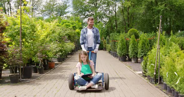 Woman Gardner Sitting on Wagon in Garden and Doing Paperwork