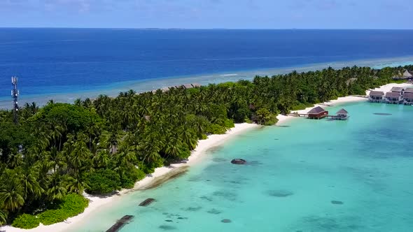 Aerial drone seascape of tourist beach by blue water with sand background