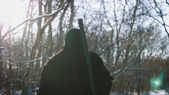 Hunting Hunter Man with Gun Walking Through the Forest During the Hunting Season