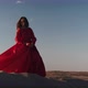 An Asian Woman in a Red Dress Gets Into a Pose on One Leg on Sand Dunes - VideoHive Item for Sale