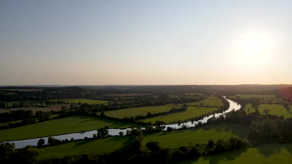 Drone flying over river Thames shores and green grassland, Mapledurham in UK. Aerial panoramic view