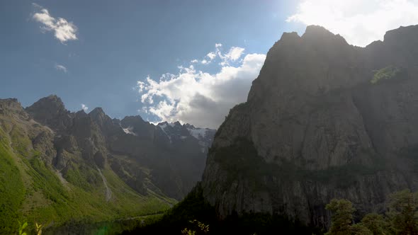 View of High Rocky Mountains with Clouds in the Sky. Timelapse.