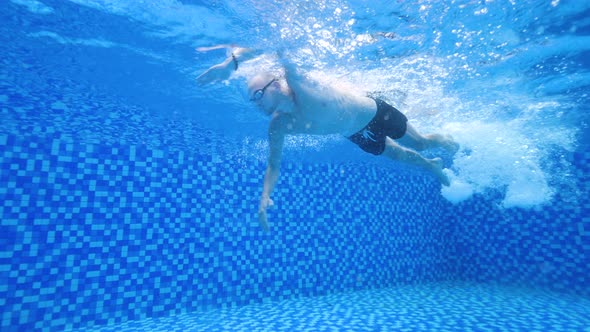 Underwater View of a Male Swimmer Swimming in the Swimming Pool at Daytime