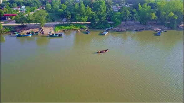 Aerial View Small Boat Sails on Green Calm River To Piers