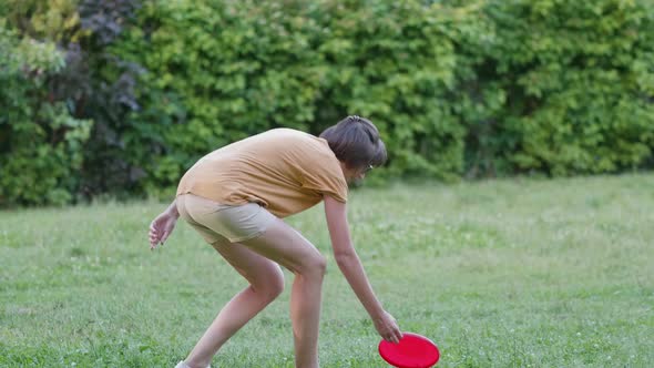 Woman Plays Frisbee on Grass Lawn