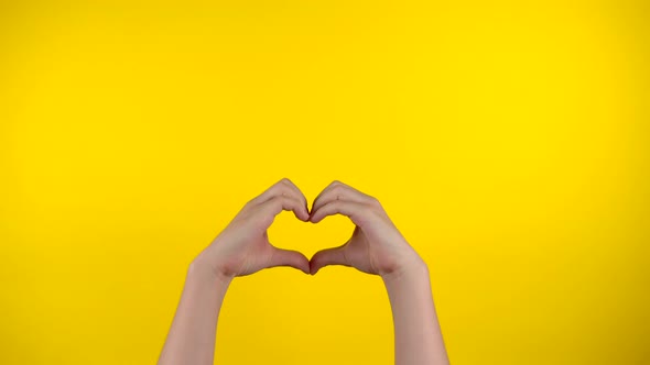 Hands Show Heart on Yellow Background Like and Love Gesturing