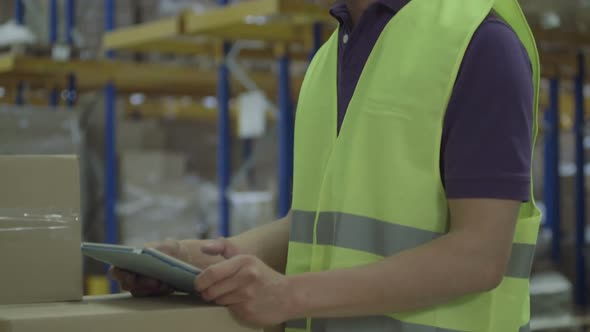 CU TU Man using digital tablet in warehouse