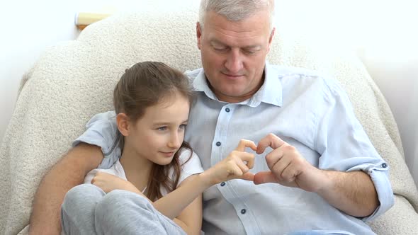 Mature Handsome Man and Little Blonde Girl are Showing Hearts By Hands Happy Family Togetherness