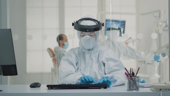 Stomatology Assistant Sitting at Desk Using Computer