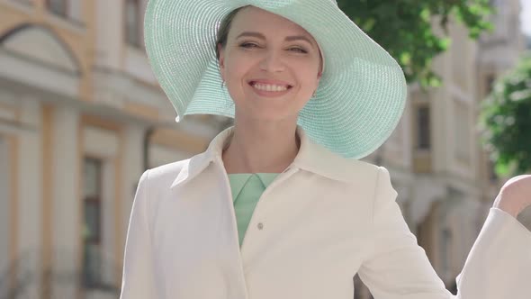 Close-up of Charming Woman Turning To Camera, Sending Air Kiss and Winking. Portrait of Beautiful