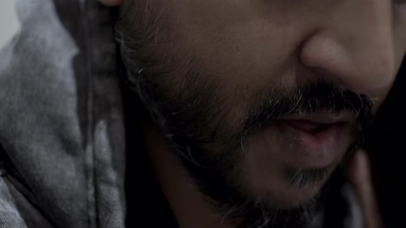 Close up of a handsome man with beard engaged in conversation with someone.