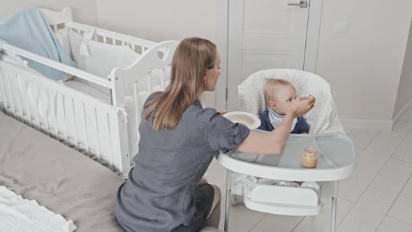 Babysitter Feeding Toddler