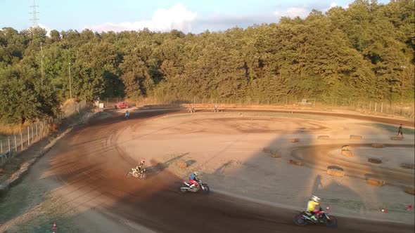 Motocross that drift on a curve of a dirt track circuit, high view