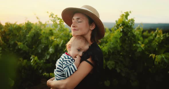 Beautiful Mother Enjoying Time with Her Cute Little Child in French Provence Vineyard During Summer