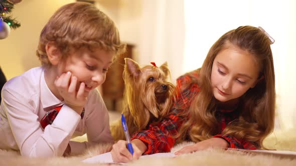 Beautiful Little Sister Helping Cute Brother Writing Letter to Santa on New Year's Eve