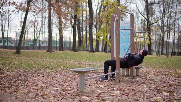 A Young Man Does Pull Ups in a Park.