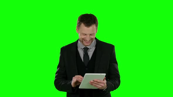 Businessman Watching Something in Laptop and Smiling. Green Screen