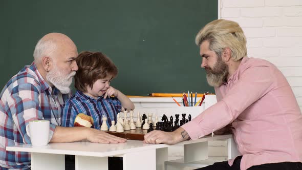 Grandfather Father and Grandson Playing Chess at Home. Games and Activities for Children, Kids Early