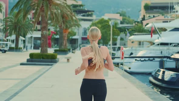 Back View of Fit Girl with Long Blonde Hair Jogging