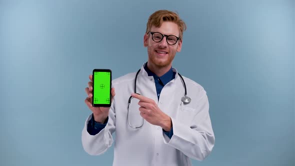 Male Online Doctor Man Show Screen on Mobile Phone Isolated on Blue Background