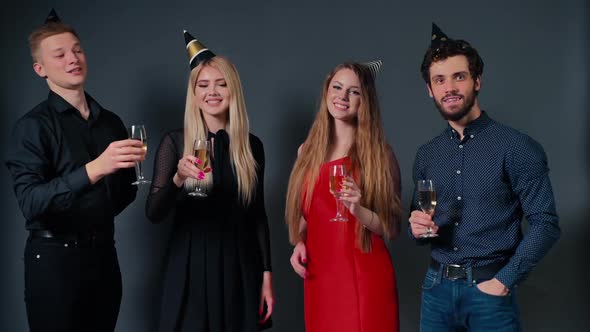 Group of Cheerful Young People Areclinking with Champagne Glasses