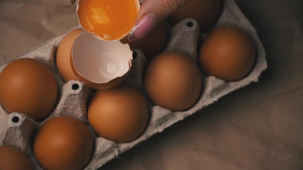 Woman's Hand Pours Chicken Yolk From One Half of the Scarloop to the Other