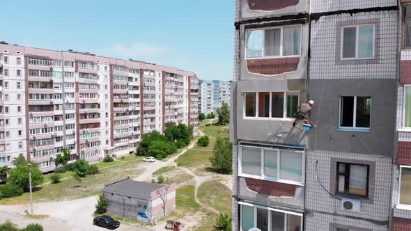 Aerial View Two Industrial Climbers Perform Work on Insulation Facade Building