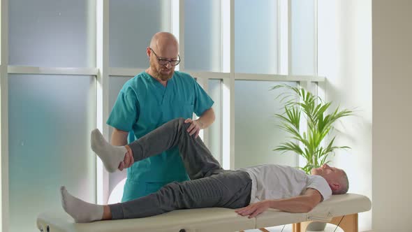 Physiotherapist Conducting a Therapy Session With an Older Man in a Rehabilitation Center.