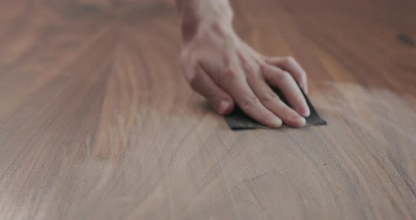 Slow Motion Slide Orbit Shot of Man Hand Sanding Black Walnut Wood Table