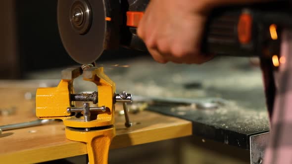 Woman locksmith works with grinder machine, fly bright sparks