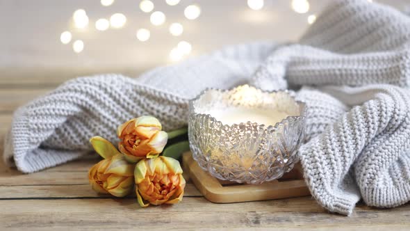 Cozy home composition for Valentine's Day with a candlestick and wooden decor details.