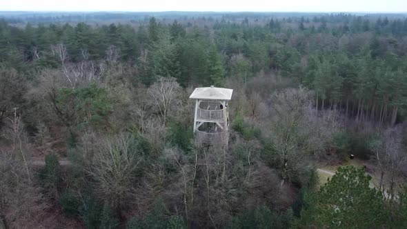 Flying with a drone around a lookout tower to spot wildlife in De Hoge Veluwe National Park in The N